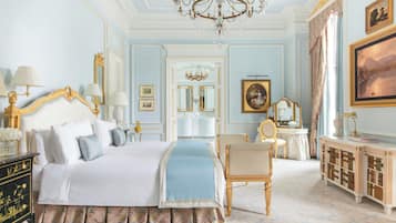 Un dormitorio amplio con una cama grande, una zona de estar y un tocador con espejo.