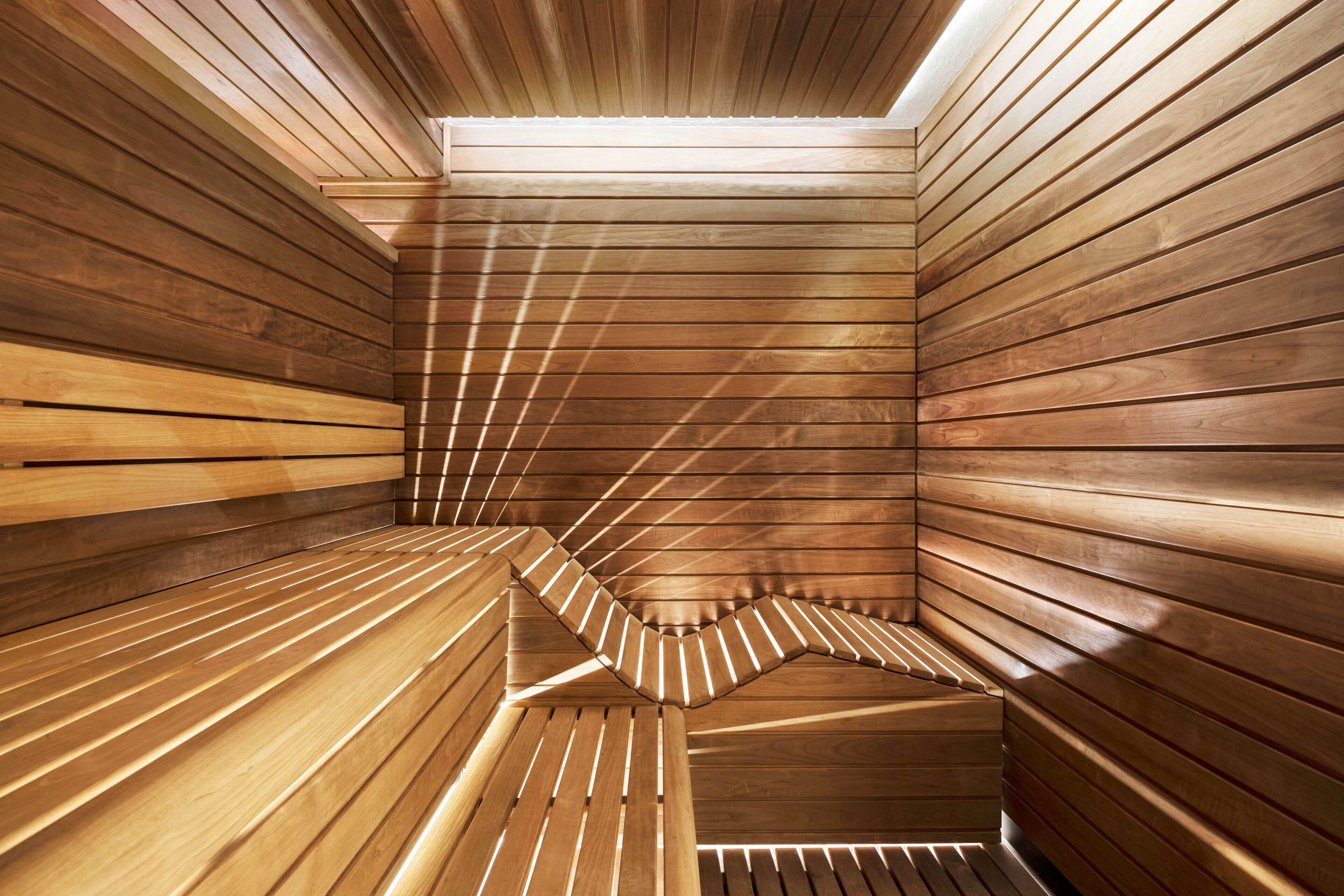 Una sauna con listones de madera y techo inclinado.