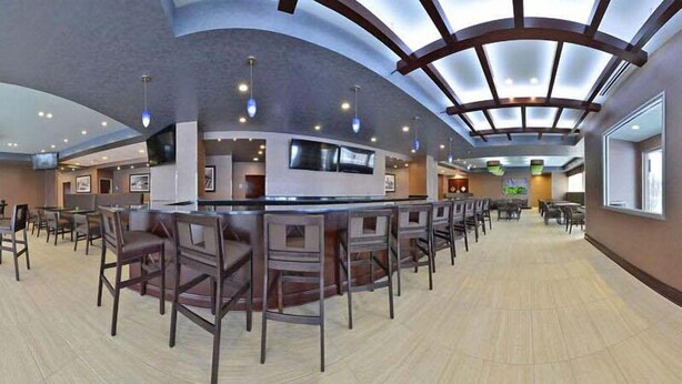Un espacio interior amplio con techo curvo, varios conjuntos de asientos y una zona de bar central.