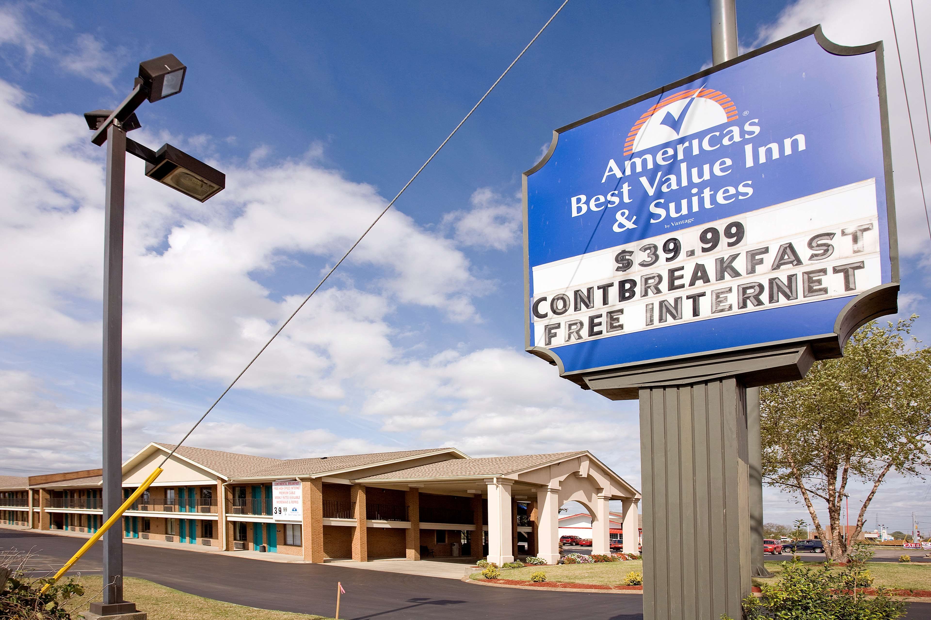 A sign for a hotel named 'Americas Best Value Inn & Suites' with a price of $39.99 for a continental breakfast and free internet.