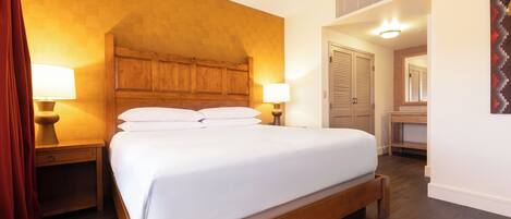 A large bed with wooden headboard, two bedside tables with lamps, and a wardrobe with sliding doors.