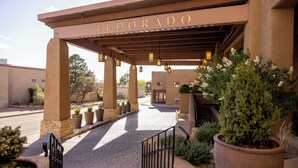 A hotel entrance with a covered walkway, potted plants, and a sign reading "ELDORADO". - Eldorado Hotel & Spa (Santa Fe)