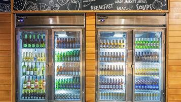 Refrigerated beverage dispensers stocked with various drinks, including wine, beer, and water.