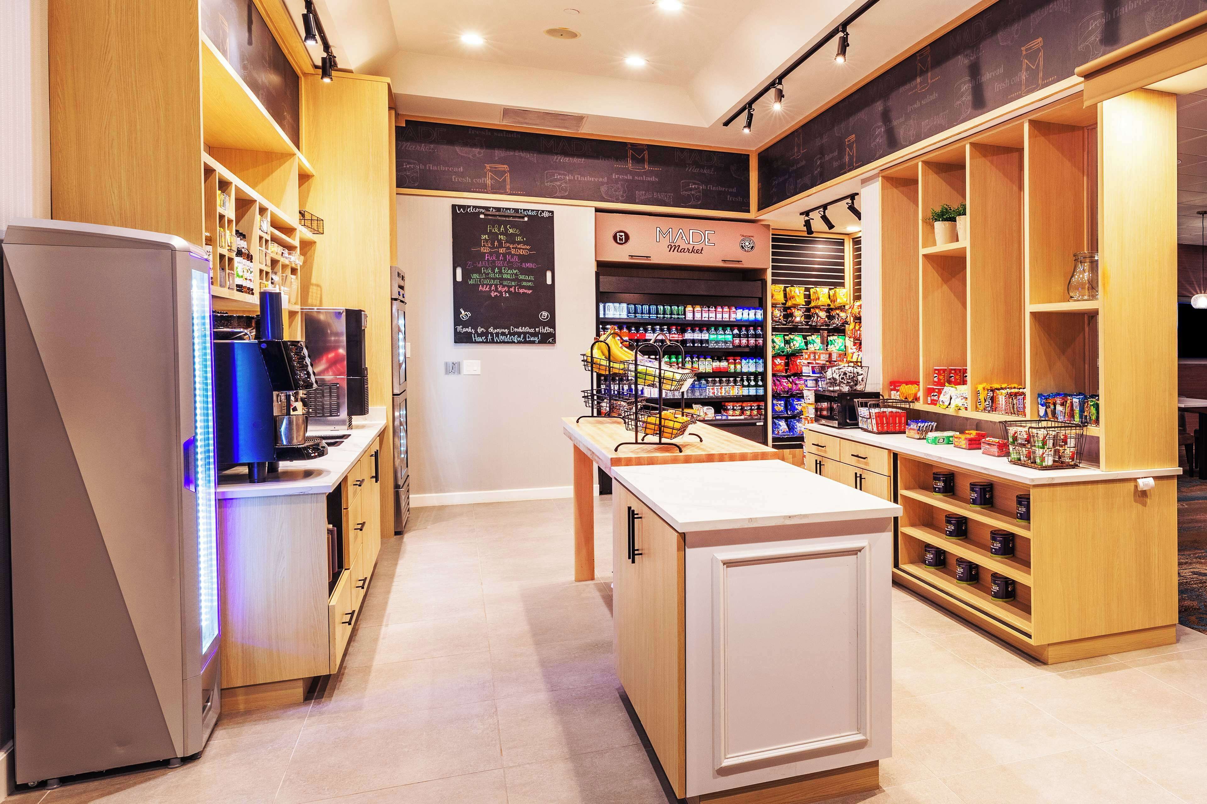 A modern kitchen with wooden cabinets, a built-in refrigerator, and a chalkboard menu.