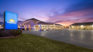 A Days Inn by Wyndham with a large illuminated sign, multiple lodging units, and a spacious parking area. - Days Inn by Wyndham St. Charles IL (St. Charles)