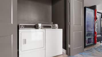 A laundry area with a washing machine and dryer, a microwave, and a refrigerator.