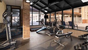 A gym with treadmills, weight machines, and a TV screen. - Days Inn by Wyndham St. Charles IL (St. Charles)