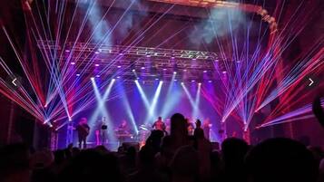 A concert stage with performers and a crowd.