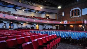 A theater with red and blue seating, a balcony, and a stage. - Days Inn by Wyndham St. Charles IL (St. Charles)