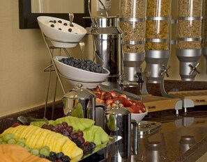 A buffet setup with various food items and beverage dispensers.