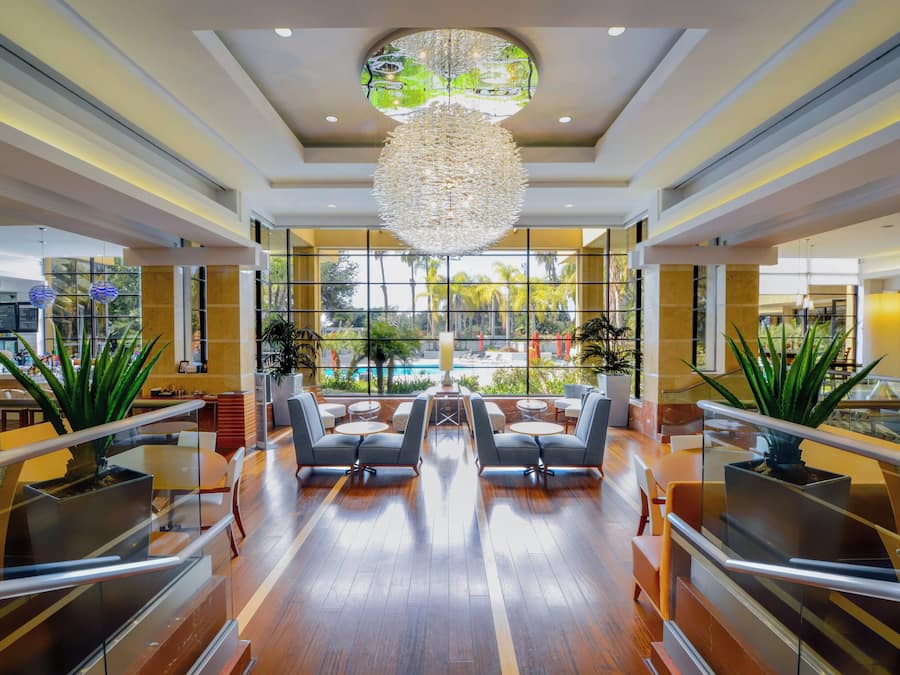 A spacious lobby with a central seating area, large windows, and a decorative chandelier.