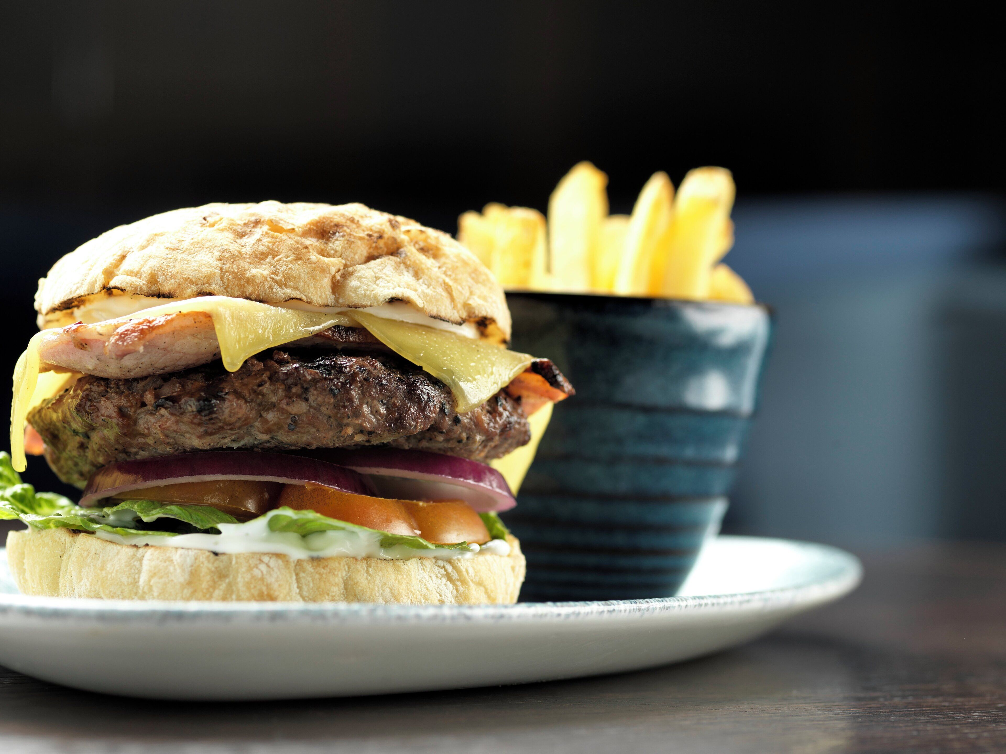 A hamburger with a side of fries on a plate.