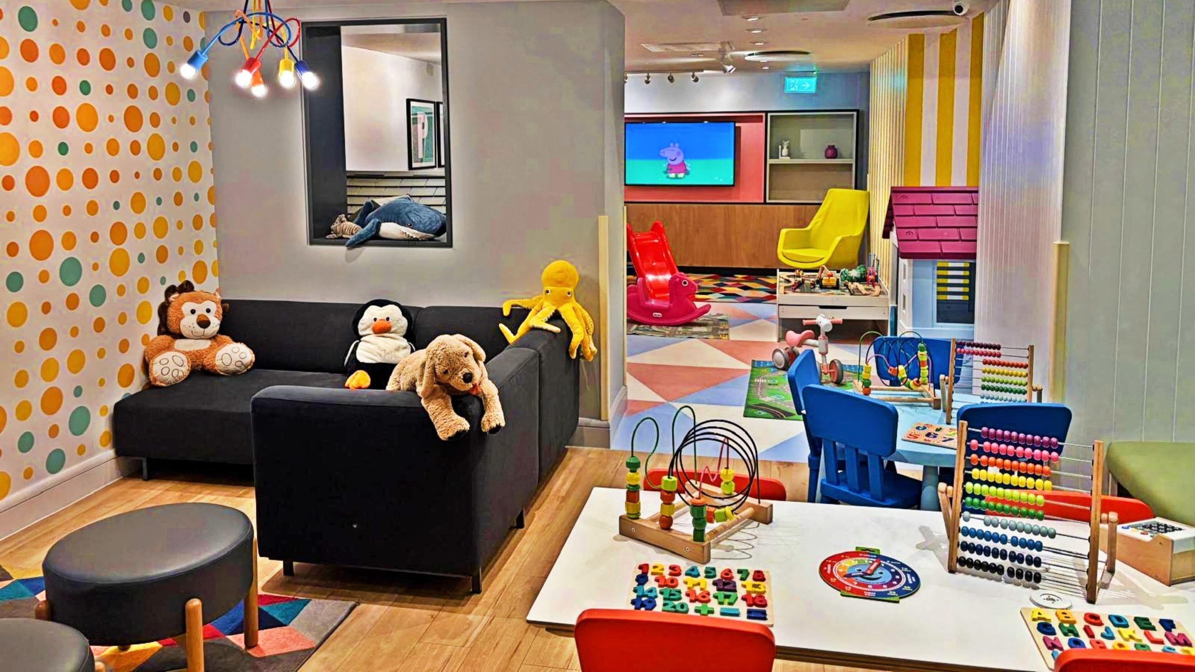 A children's playroom with a sofa, toys, and educational toys.