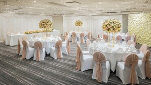 A banquet hall with round tables, white tablecloths, and floral centerpieces. - Holiday Inn Southampton-Eastleigh M3, jct13 by IHG (Eastleigh)