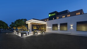 A Holiday Inn hotel with a modern design, featuring a well-lit entrance and a parking area. - Holiday Inn Southampton-Eastleigh M3, jct13 by IHG (Eastleigh)