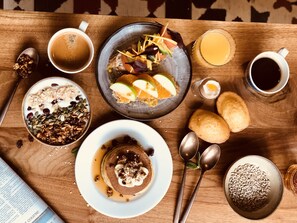 A wooden table with breakfast items including pancakes, cereal, and fruit. - Mercure Paris Centre Gare Montparnasse (Paris)