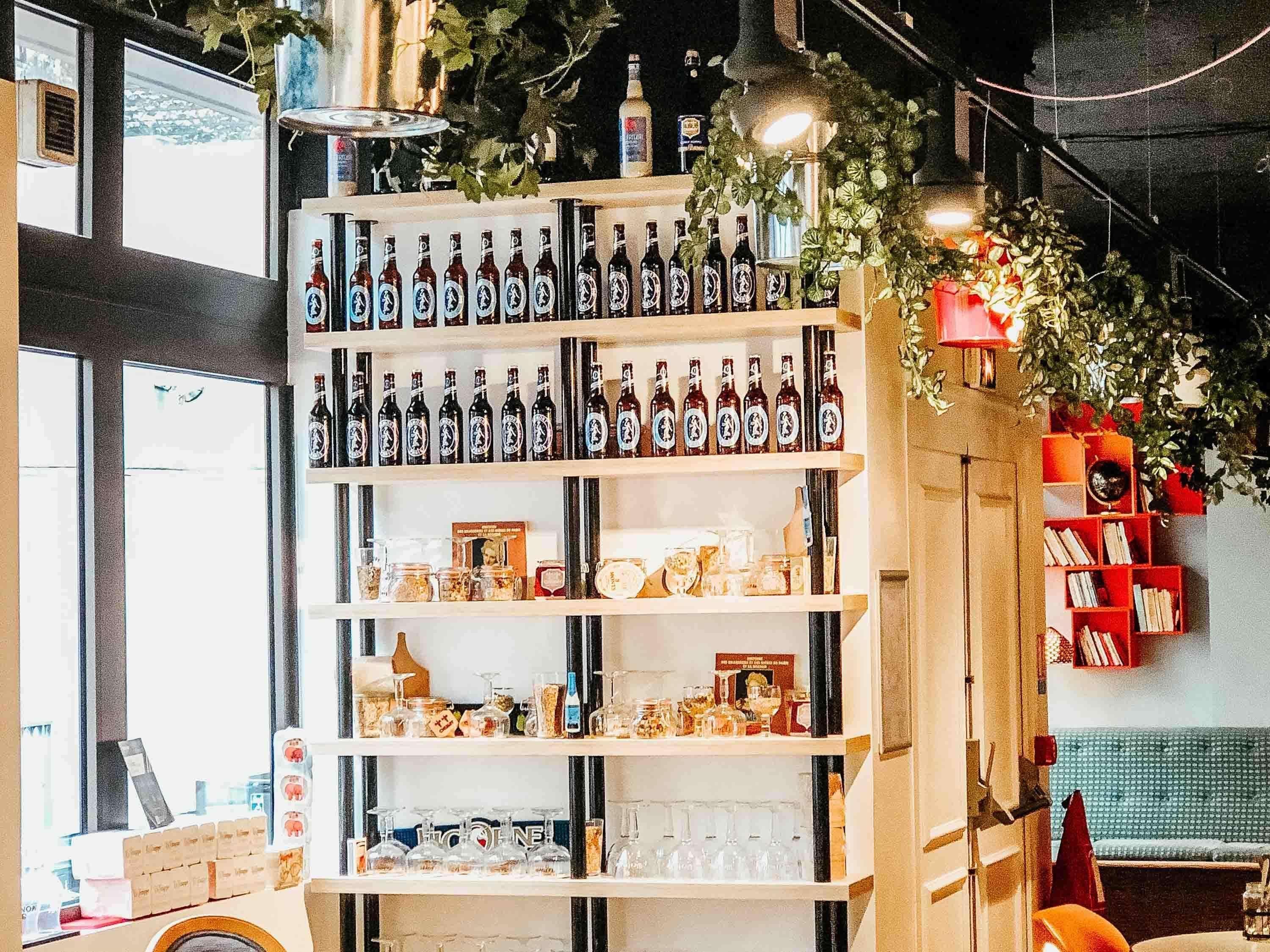 Un espace bar avec des étagères remplies de bouteilles, de verres et de pots.