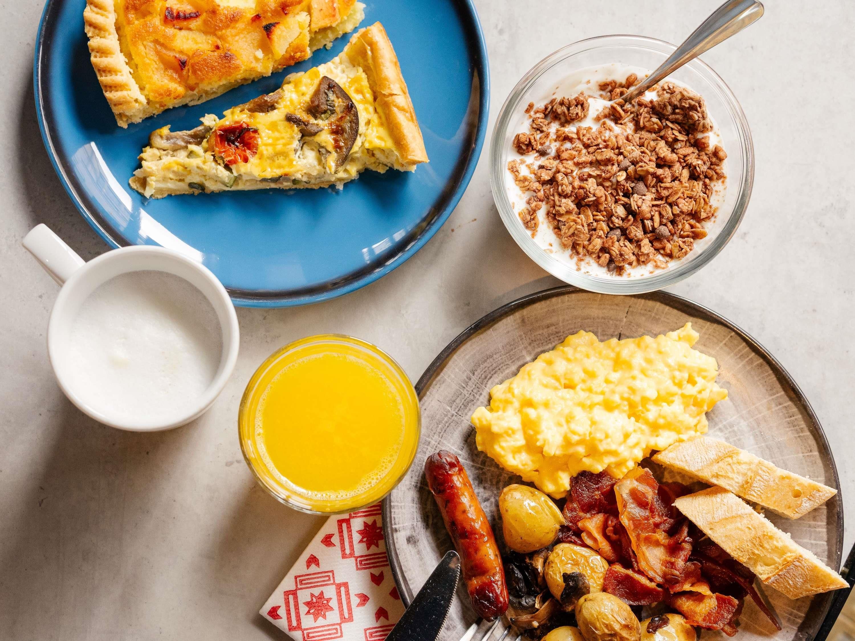 Un plato de desayuno con huevos revueltos, tostadas, salchicha y tocino.