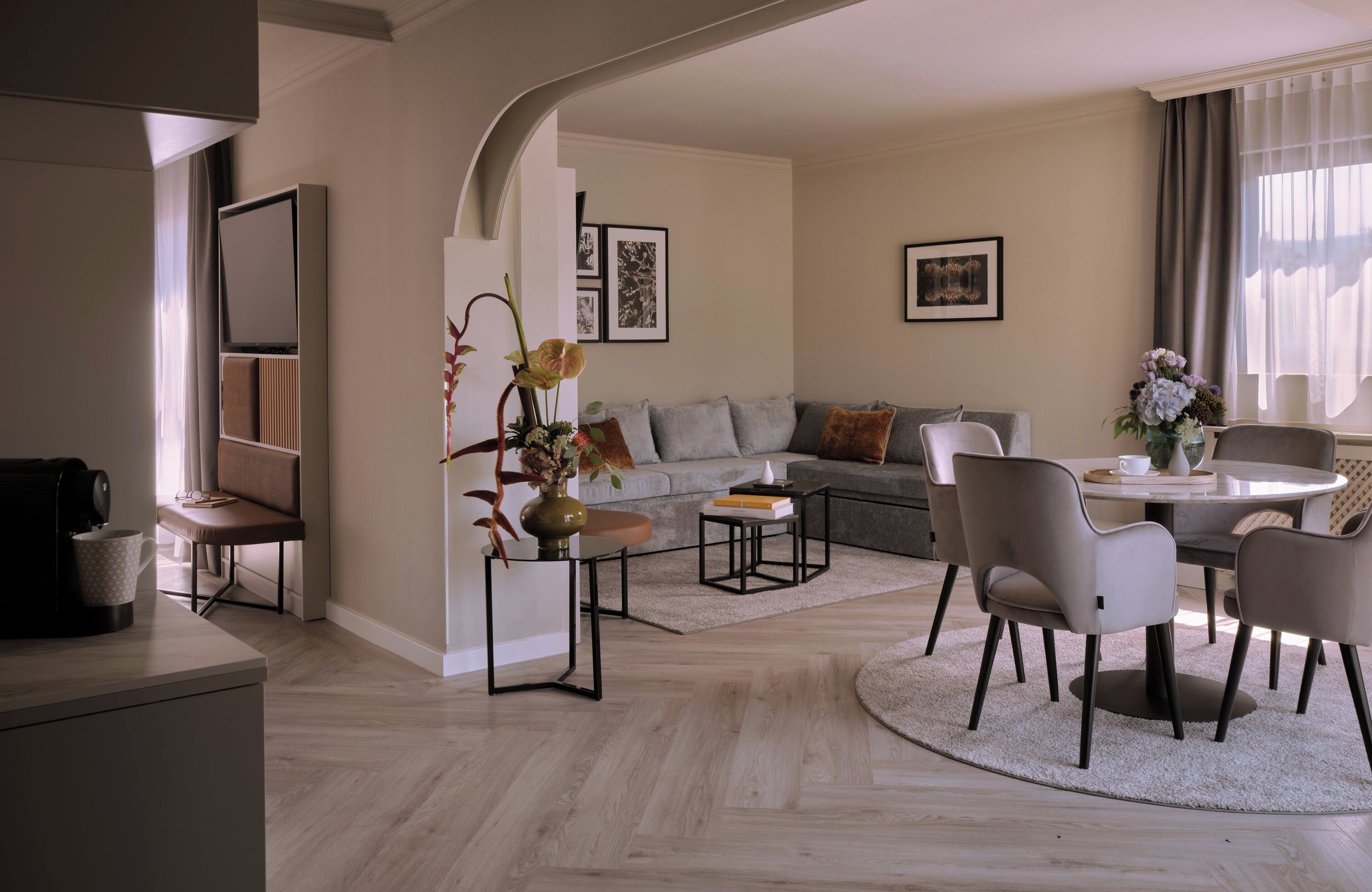 A modern living room with a sofa, chairs, a coffee table, and a dining area.