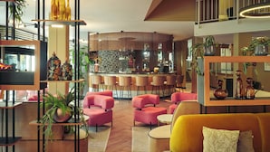 Ein moderner Lounge-Bereich mit Bar, Sitzgelegenheiten und Zierpflanzen.