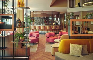 Uma área de estar moderna com bar, assentos e plantas decorativas.