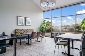 Enjoy a meal with a view in this stylish dining area, featuring a large window and comfortable seating for all.