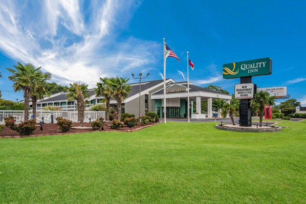 Quality Inn features a modern architectural design with a prominent entrance and well-manicured lawn.