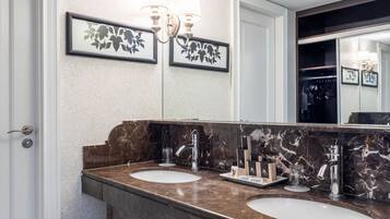 A bathroom with two sinks, marble countertops, and a large mirror.