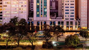 Un hotel grattacielo con una torre imponente, numerosi piani e una facciata ben illuminata.