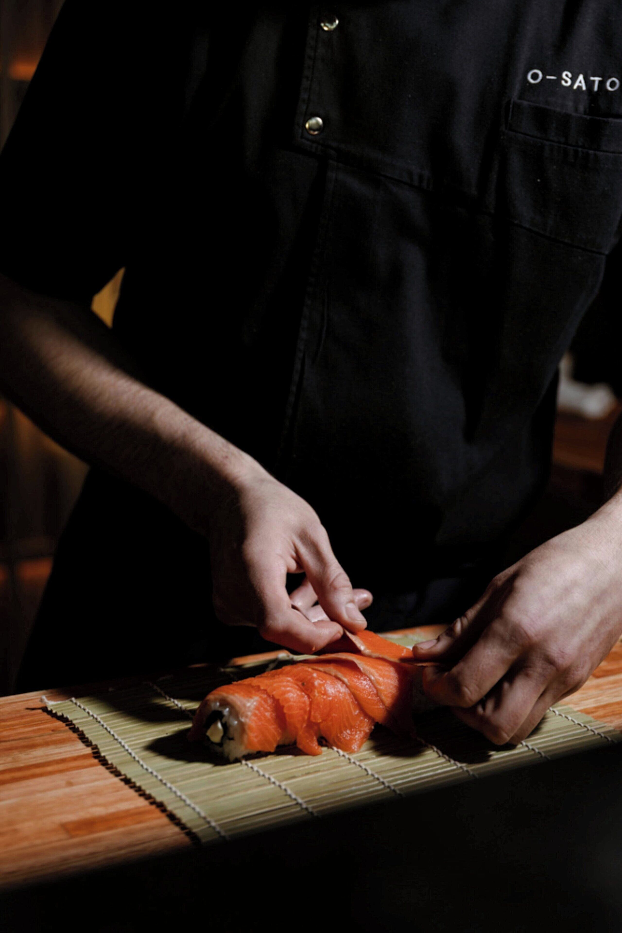 Une personne préparant des aliments sur une planche à découper.