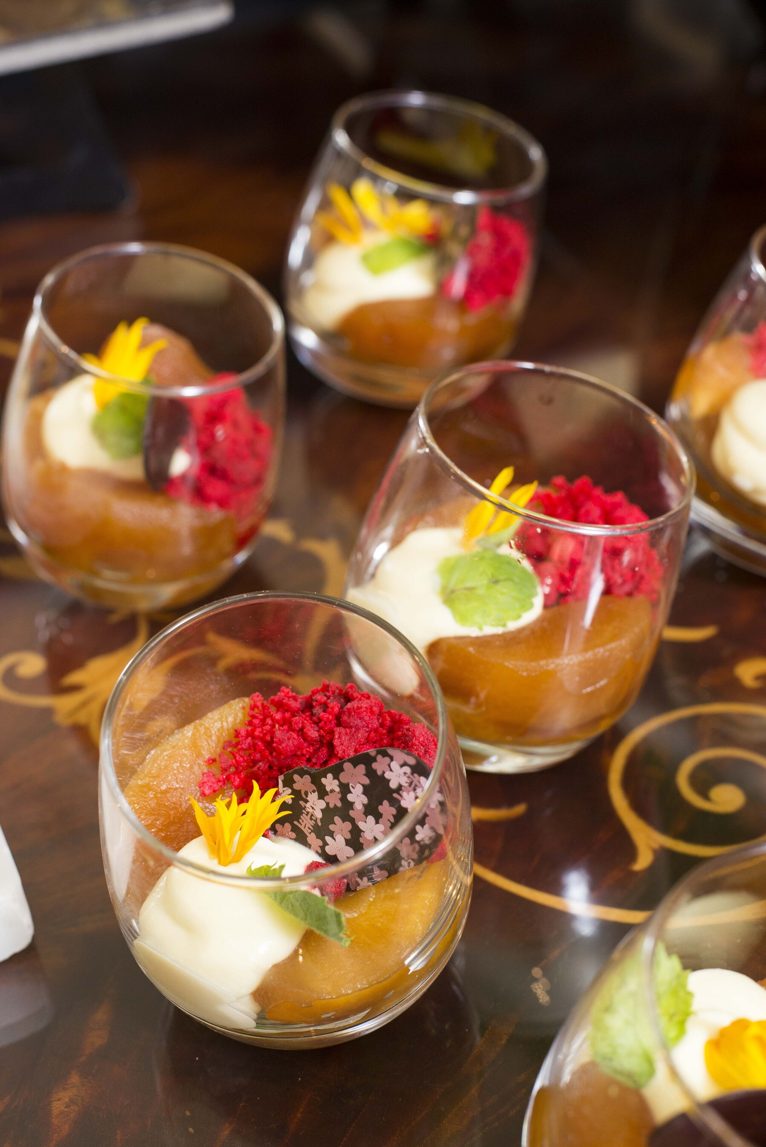 Une présentation de desserts comprenant plusieurs verrines contenant différents fruits et de la crème.