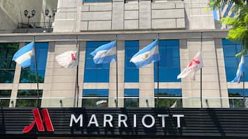 A Marriott hotel facade with multiple flags, including the Argentine flag, and a prominent 'MARRIOTT' sign.