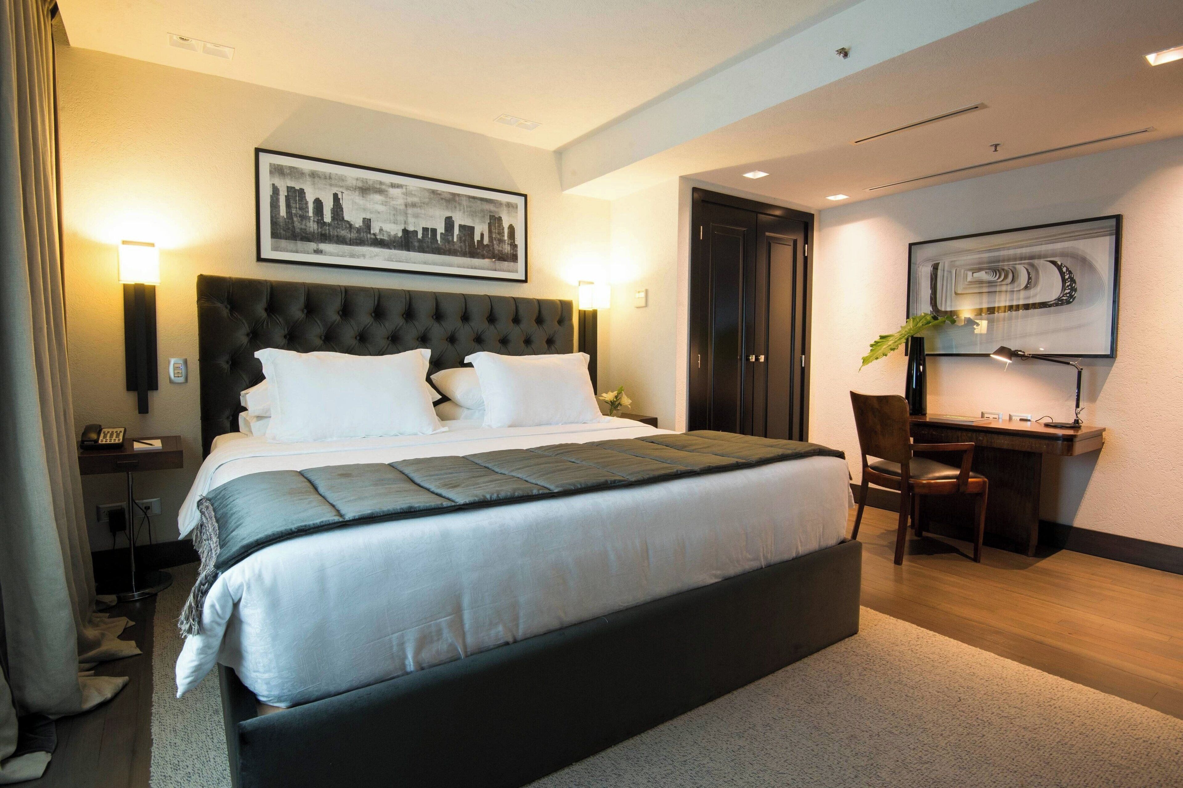 Une chambre d’hôtel moderne avec un grand lit, un bureau et une chaise.