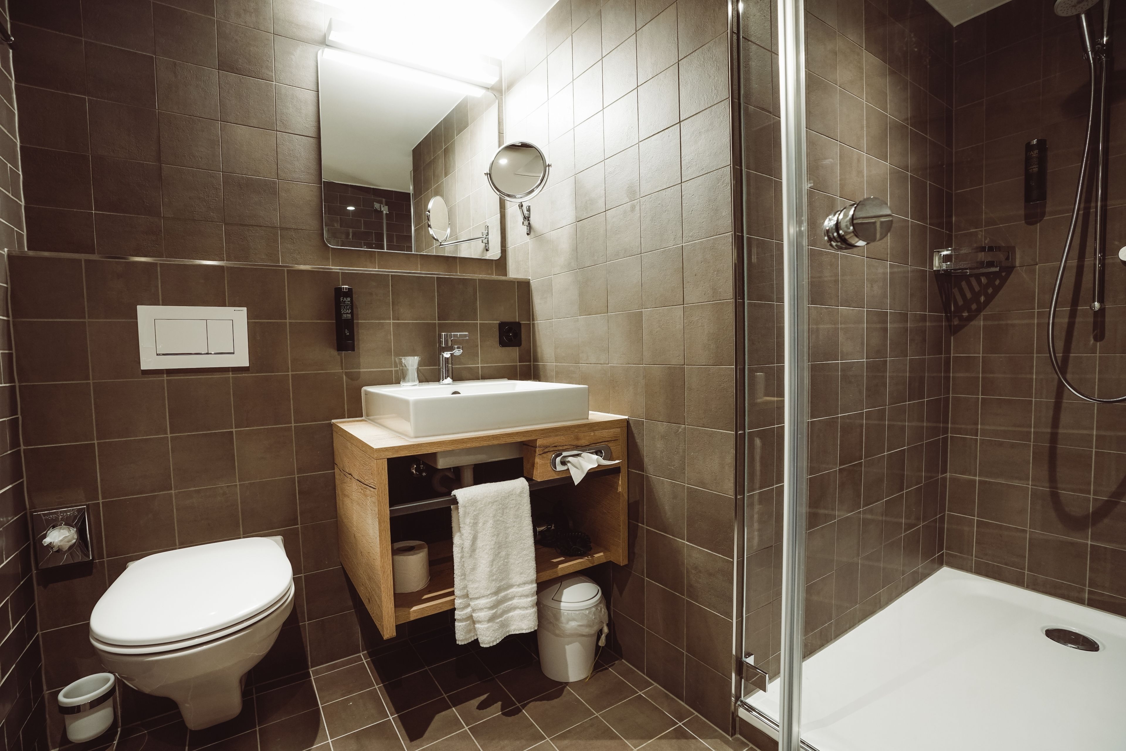 Une salle de bain moderne équipée de toilettes, d’un lavabo et d’une douche.