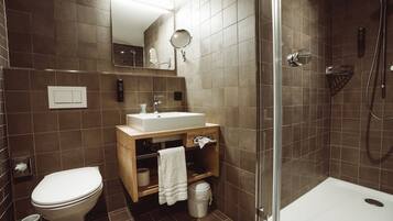 Une salle de bain moderne équipée de toilettes, d’un lavabo et d’une douche.