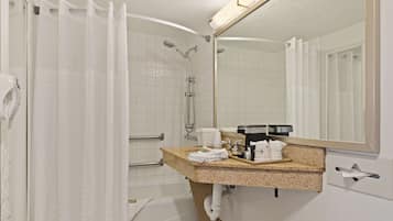 A bathroom with a shower, a sink with a mirror, and a towel rack.