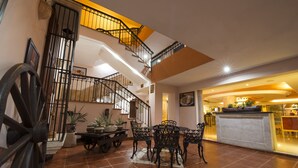 A spacious dining area with a high ceiling and a staircase leading to an upper level. - Hotel Del Gobernador (Mérida)