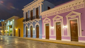 A street with buildings featuring balconies and ornate architectural details. - Hotel Del Gobernador (Mérida)