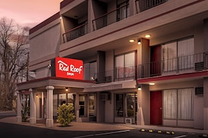 A Red Roof Inn with a two-story structure, balconies, and a red sign.