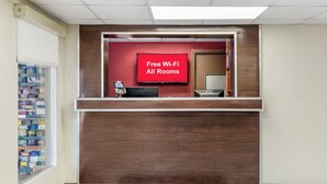Una recepción con un letrero rojo que indica Wi-Fi gratuito en todas las habitaciones.
