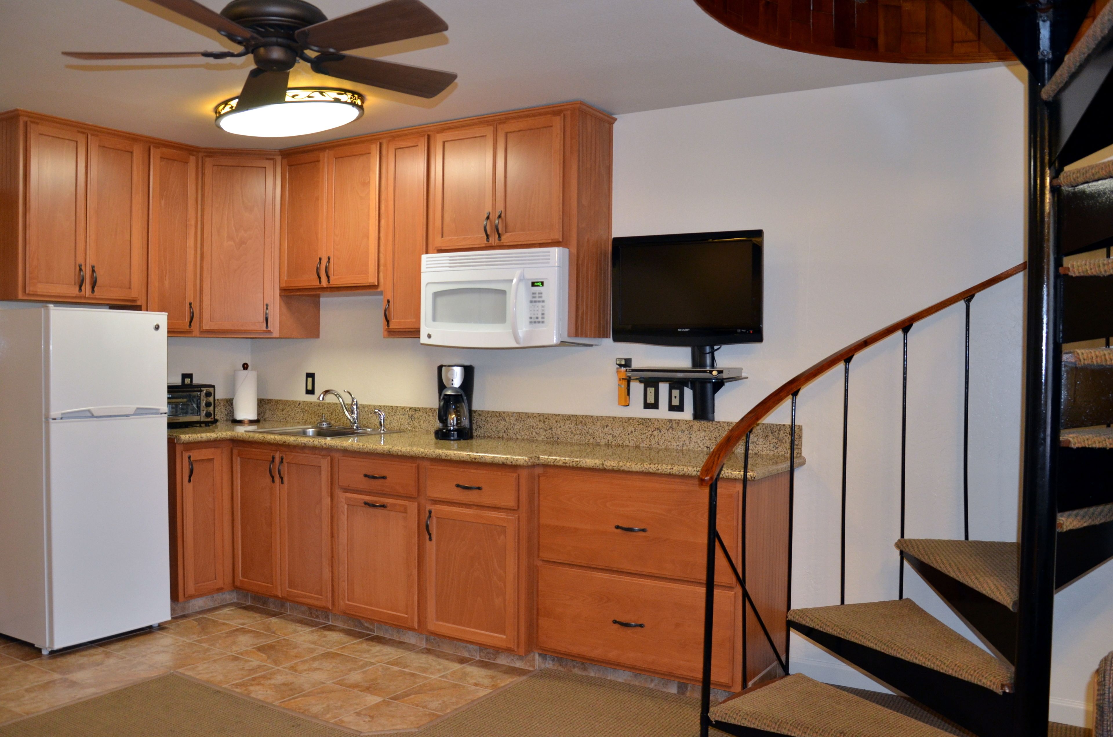 A kitchen with wooden cabinets, a microwave, a toaster, and a coffee maker.