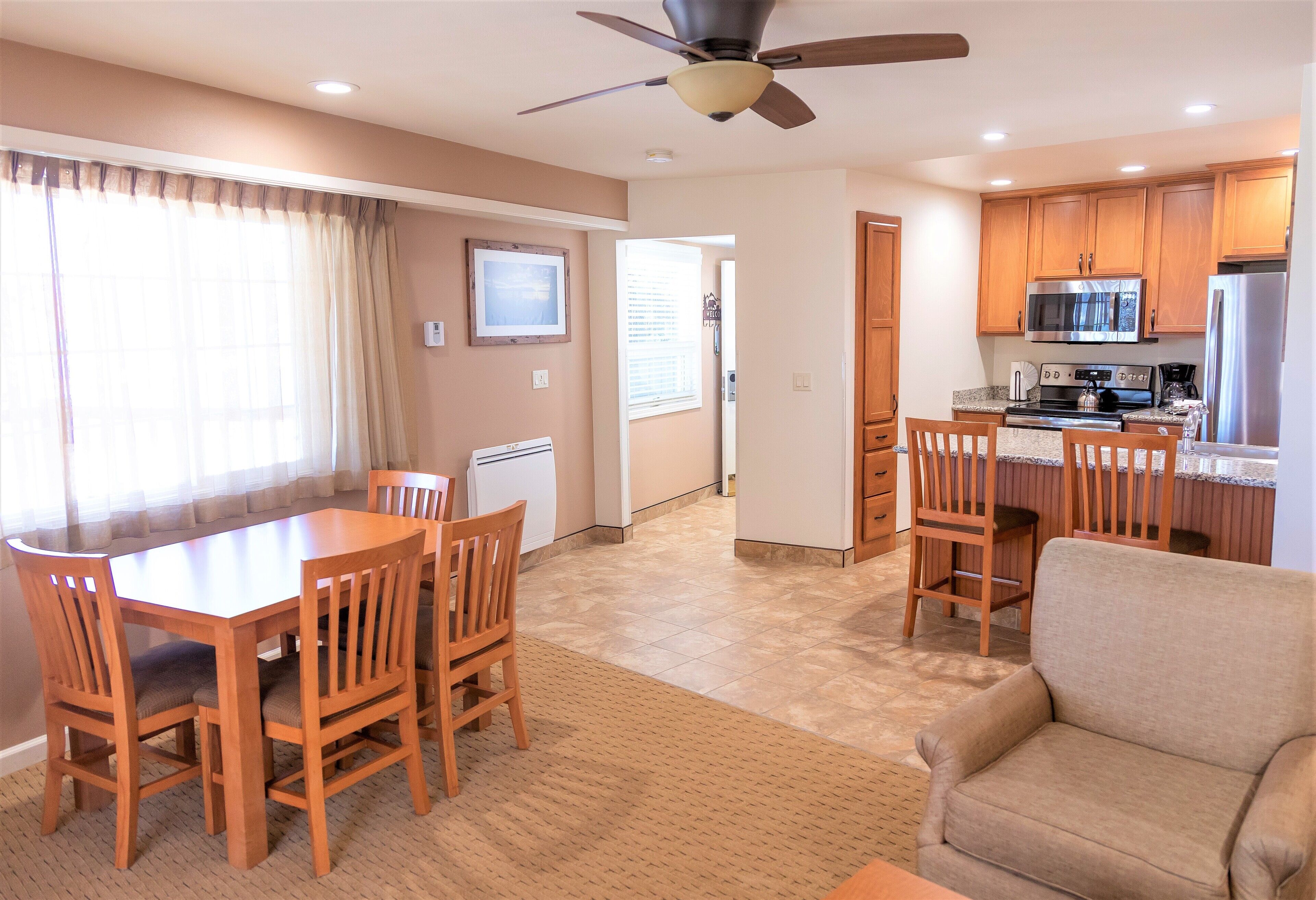 A compact kitchen with wooden cabinets, a microwave, and a refrigerator.