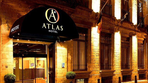The exterior of the Atlas Hotel with a black awning, stone facade, and a sign indicating the hotel name. - Atlas Hotel Brussels (Brussels)