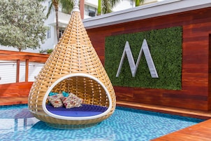 Una piscina al aire libre, camas de piscina con cargo, sombrillas