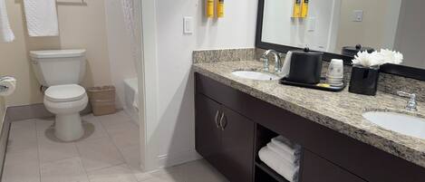 Un baño moderno con inodoro, lavamanos y tocador.
