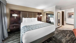 A hotel room with a large bed, a bedside table, a mirror, and a view of the bathroom. - Best Western Plus Redondo Beach Inn (Redondo Beach)