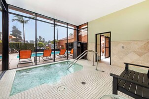 Una piscina al aire libre, sombrillas, sillones reclinables de piscina