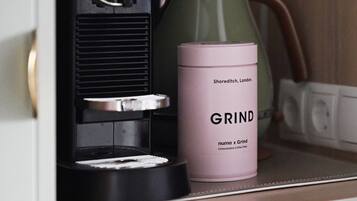 A coffee machine and a container labeled "GRIND" on a countertop.
