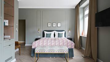 A bedroom with a bed, bedside tables, a TV, and a wardrobe.