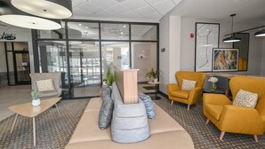 Eine moderne Lobby mit Empfangstresen, Sitzgelegenheiten und großen Fenstern.